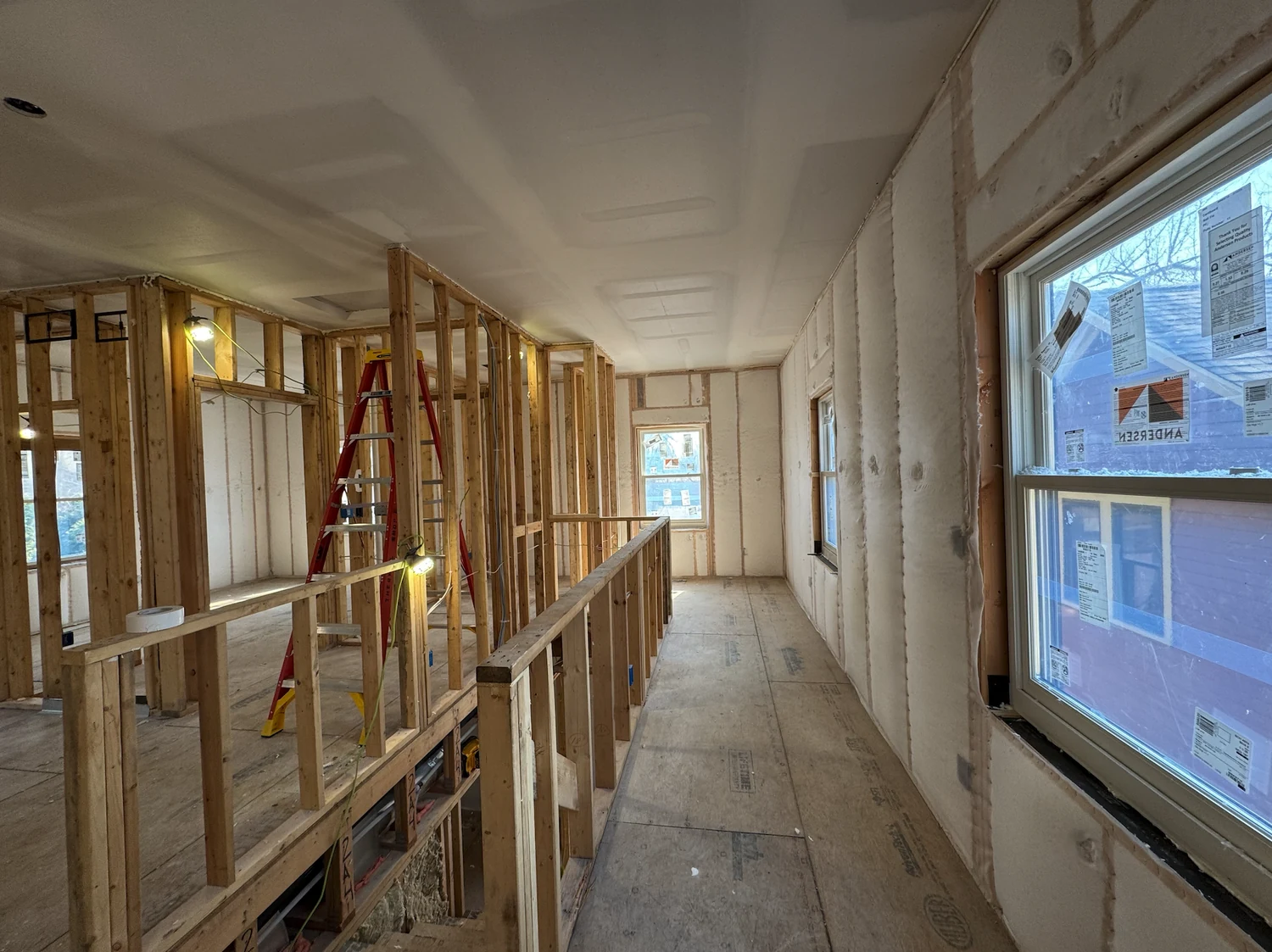 Upstairs loft with netted walls, a stair railing, and a ladder