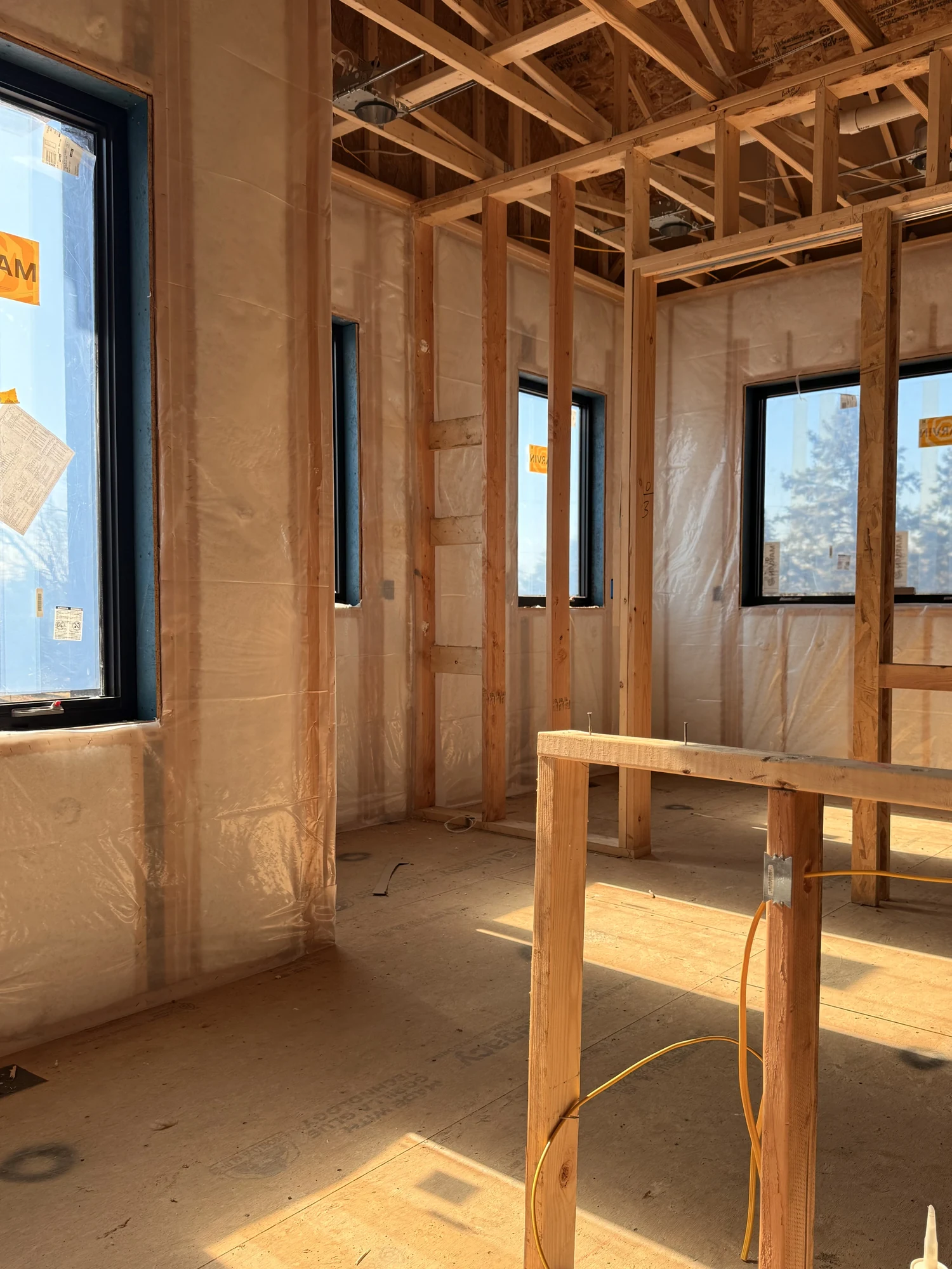 Netted, filled exterior walls seen through open interior wall framing