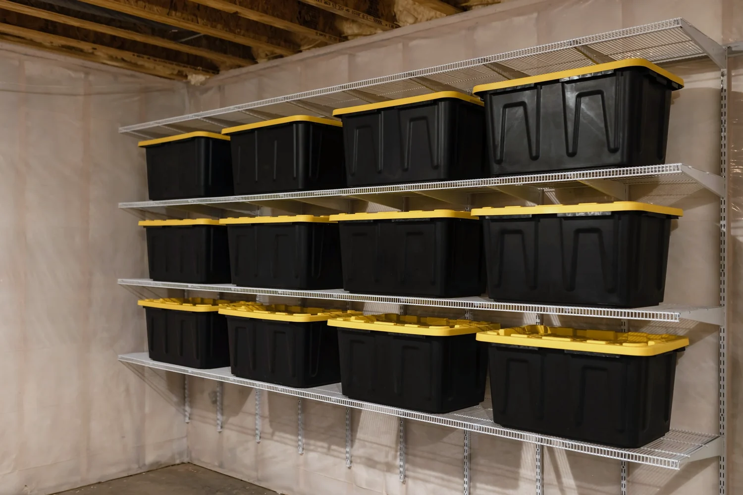 Storage bins lined up on white wire shelves along a basement wall