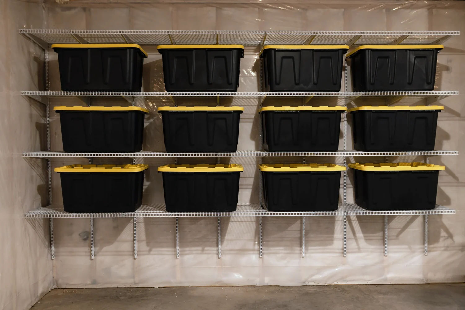 Straight-on view of storage bins on white wire shelves in a basement