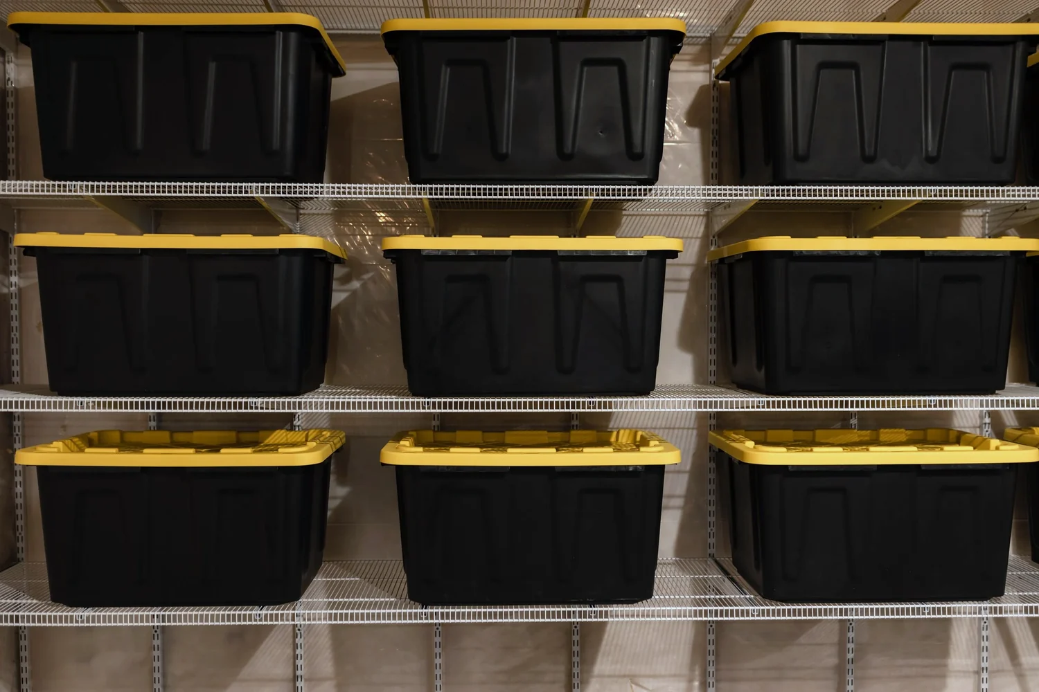 Close view of storage bins resting on white wire shelves