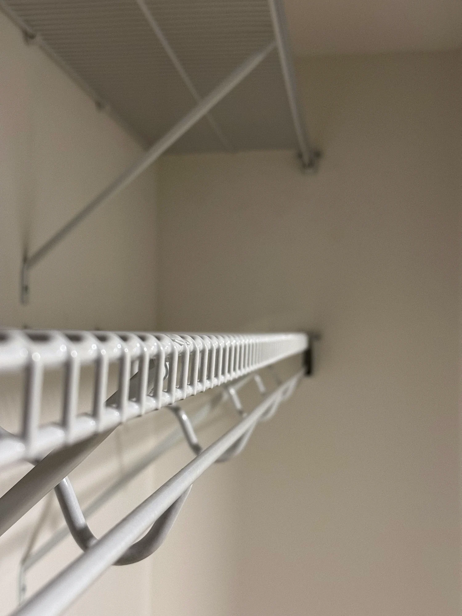 Close view of the end of a wire closet shelf and its hanging rod