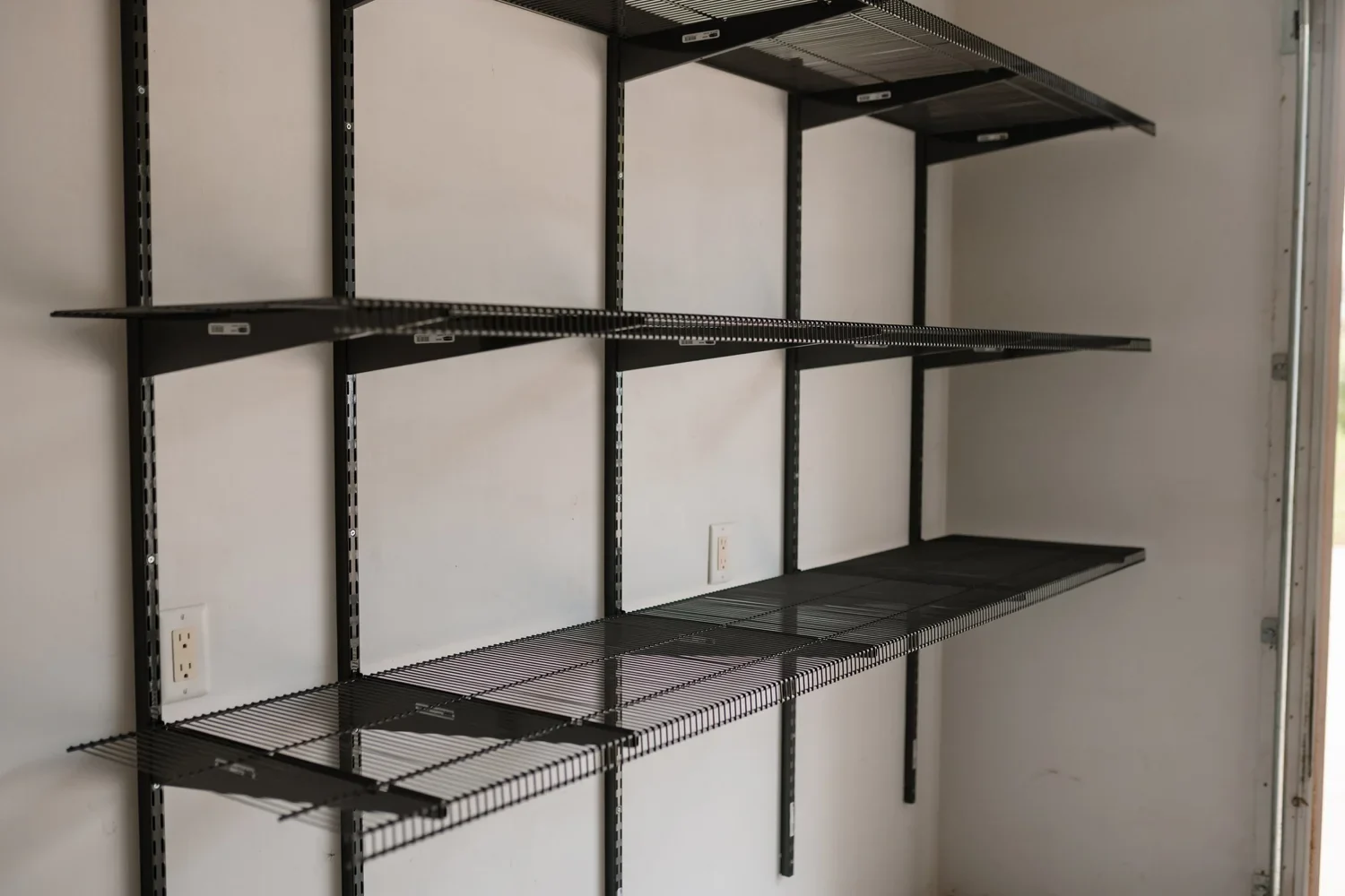 Angled view of empty gunmetal shelves on brackets and wall rails